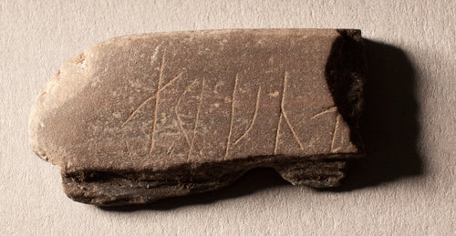Viking archaeological whetstone with runic carving